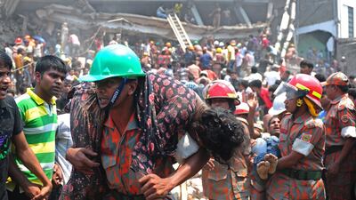 A Bangladeshi firefighter carries an injured garment worker. AFP Photo / Munir uz Zaman