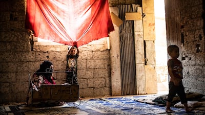 A Syrian mother, displaced with her family from Deir Ezzor, rocks a baby to sleep inside the damaged building where she is living in Syria's northern city of Raqqa.