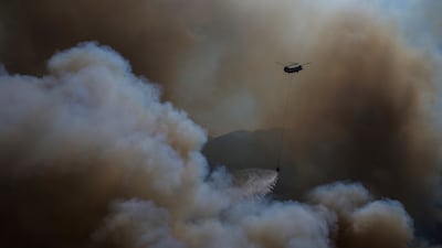 A helicopter drops water over a fire in Mugla, Turkey. AP