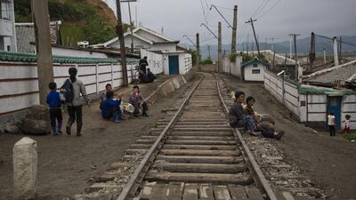 In this June 20, 2014 photo, North Koreans seen resting next to the railroad tracks in a town in the North Hamgyong province. The Associated Press was granted permission to embark on a weeklong road trip across North Korea to the country’s spiritual summit Mount Paektu, but on the terms of Pyongyang as government 'minders' accompanied them the entire way. David Guttenfelder/AP Photo