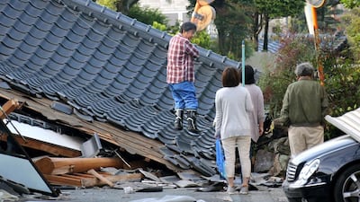 Residents look for an access to their home on the road which is blocked by a collapsed house, in Mashiki, Kumamoto prefecture, southern Japan. A major quake shook southwestern Japan, barely a day after another quake hit the same region. Naoya Osato / Kyodo News via AP