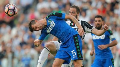 Sassuolo defender Francesco Acerbi heads a ball away from Juventus' Gonzalo Higuain. Marco Bertorello / AFP