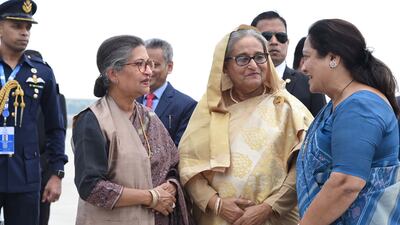Bangladesh Prime Minister Sheikh Hasina, centre, is greeted by Indian Minister of State for Agriculture and Farmers' Welfare Shobha Karandlaje, right, on her arrival in Delhi for the G20 summit. EPA