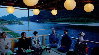 Houkan (male counterpart to geisha) Tatsuji, 29, and maiko (apprentice female geisha), Kikuyu, 20, sit with visitors to watch cormorant fishing or ukai, at a riverside observation deck in the Nagara River, Japan. Reuters
