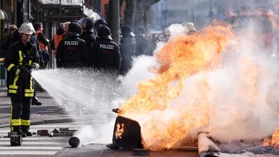 A fireman extinguishes a burning barricade during a Blockupy demonstration. Marius Becker / EPA