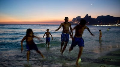 Kids from the Cidade de Deus shantytown play football on Ipanema Beach at sunset in Rio de Janeiro. Christophe Simon / AFP Photo