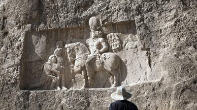 A European tourist looks at the over-lifesized rock relief triumph of Sassanid emperor Shapur I over the Roman Emperor Valerian, and Philip the Arab at Naqsh-e Rostam necropolis, located about 12km northwest of Persepolis, near Shiraz. Although many hotels have been built in the sprawling conurbations of Mashhad, Esfahan and Shiraz, the closest city to Persepolis, they are primarily for the domestic market. In the tourism sector there is a specific need for customer-focused training and more development. Behrouz Mehri / AFP