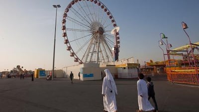People walk near the Ferris wheel at Dubai’s Global Village where an Emirati man died last month. Jaime Puebla / The National