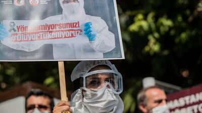 Turkish doctors hold placards reading 'you cannot manage, we are exhausted, we die' during a protest against the government in front of the Istanbul Faculty of Medicine, in Istanbul. EPA