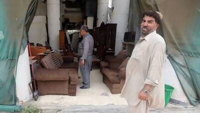 A Hussain, left, a customer looks through discarded household goods while Naiem, right, watches from buildings earmarked for demolition July 1, 2013. Sammy Dallal / The National