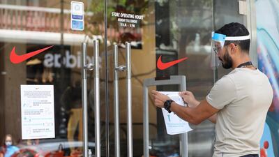 An employee puts a sign indicating safety measures on a shop front in Beirut, Lebanon. Reuters