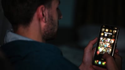 An Afghan student uses his mobile phone at his residence in Kabul on October 8, 2025. AFP