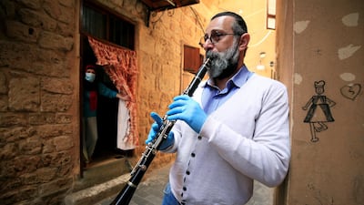 Tarek Bashasha, a 49 year-old artist, plays the clarinet to entertain people at their homes, during a countrywide lockdown in Sidon's old city, southern Lebanon. Reuters