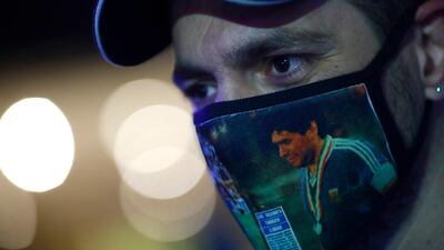 A fan wearing a face mask with images of Diego Maradona looks on outside Clínica Olivos on November 03, 2020 in Olivos, Argentina. Getty Images