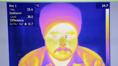 Malkit Singh goes through a temperature scanner at the Guru Nanak Darbar Sikh temple in Dubai. The scanners have been installed to help combat the spread of coronavirus. Chris Whiteoak / The National