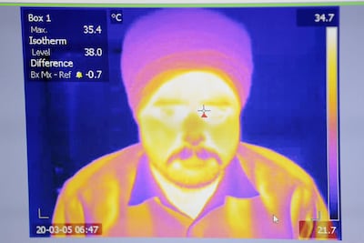Malkit Singh goes through a temperature scanner at the Guru Nanak Darbar Sikh temple in Dubai. The scanners have been installed to help combat the spread of coronavirus. Chris Whiteoak / The National