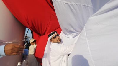 A large UAE flag being launched as Ras al Khaimah prepares to celebrate UAE's 42nd National Day. Sammy Dallal / The National