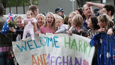 Children hold a banner as they wait for the arrival of the royal couple. EPA