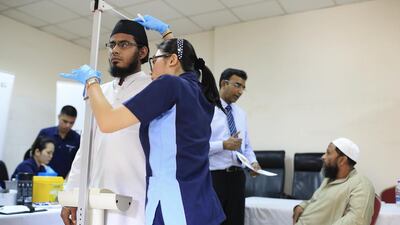 Nursing assistant Farha Mansan checks Said Imran’s height and weight at a Pakistan Association Dubai health-awareness drive. Sarah Dea / The National