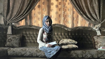 Hadeel Ziad clutches a copy of her novel in her family home in the Mosul Jadida neighbourhood. Photo: Florian Neuhof