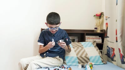 Mohammed shows off his toys in his room. He was left without a birth certificate after his father abandoned him at birth. Reem Mohammed / The National