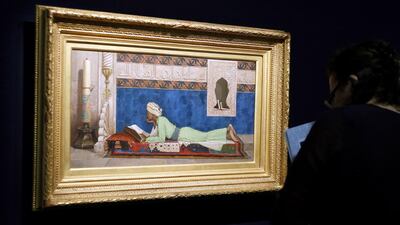 A woman looks at Osman Hamdi Bey’s 1878 painting A Young Emir Studying at the Louvre Museum in Paris in April 2014. Francois Guillot / AFP