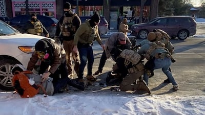 A law enforcement officer pins down Mr Pretti, before he was fatally shot. Reuters