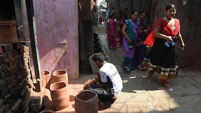 A potter sanding a pot behind the "Colour Box", one of the venues of the Dharavi biennale that started on February 15. Indranil Mukherjee / AFP
