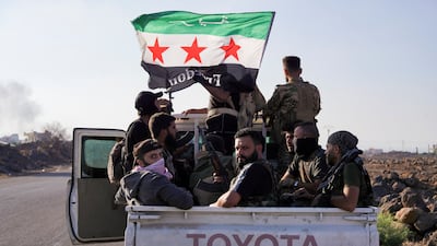 Members of Syria's security forces sit together in the back of a truck, amid fighting in Sweida. Reuters