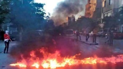 Anti-regime protesters in Damascus block a street by burning tyres in a demonstration today. Shaam News Network / AFP Photo