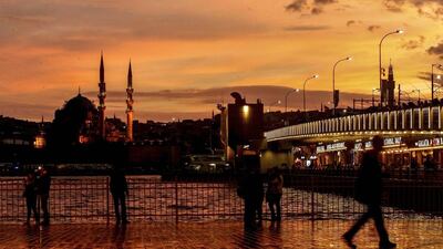 People walk as the sun sets over the Galata Bridge in Istanbul, Turkey. Emrah Gurel / AP Photo
