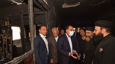 Mostafa Madbouly speaks to officials at the blaze site. AFP