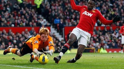 Bolton's Adam Bogdan dives at the feet of Manchester United's Danny Welbeck.