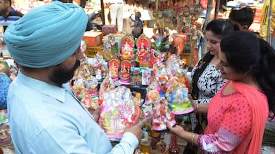 Indian shoppers look for idols of Hindu goddess Laxmi and Lord Ganesh on the eve of the Hindu festival of "Diwali", in Amritsar on November 6, 2018. "Diwali", the Festival of Lights, marks victory over evil and commemorates the time when Hindu god Lord Rama achieved victory over Ravana and returned to his kingdom Ayodhya / AFP / NARINDER NANU