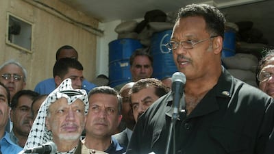 Jackson speaks to the press in Ramallah, in the occupied West Bank, as Palestinian leader Yasser Arafat, left, looks on, July 2002. AFP