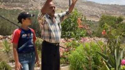 Jamal Najar, right, is convinced settlers fired at his home. Below, Wahib Qadous shows the picture of a rocket on his mobile phone.
