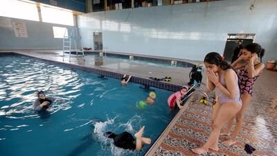 Swimming coach Elaf gives instructions as children practise diving at a pool in Basra. Reuters