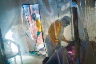 Health workers wearing protective suits tend to an Ebola victim kept in an isolation cube in Beni, Congo, in July 2019. Jerome Delay / AP