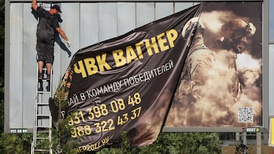 On the outskirts of Saint Petersburg, a banner promoting the Wagner private mercenary group is taken down from view. Reuters