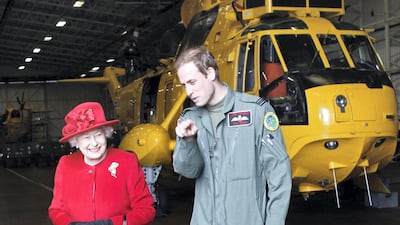 Queen Elizabeth is escorted by her grandson Prince William during a visit to RAF Valley where Prince William was stationed in 2011. Getty Images
