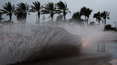 A car drives along a flooded street ahead of the expected arrival of Hurricane Nicole, in Daytona Beach, Florida. Reuters