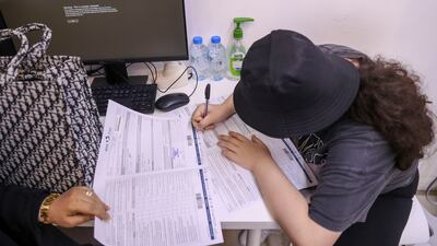 Dalaa Alaa Aladwan, 14, from Rosary School, signs forms to be vaccinated.