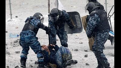 Riot police officers hold a man lying on the ground during clashes between police and pro-European protesters. Vasily Fedosenko / Reuters