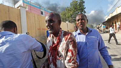 Somalis help a man wounded after a blast in the capital Mogadishu. Farah Abdi Warsameh / AP Photo