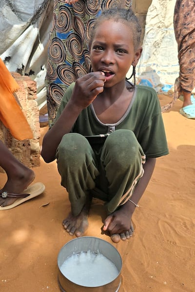A Sudanese child receives food at Al Rahmaniyah displacement camp near Al Obeid. AFP