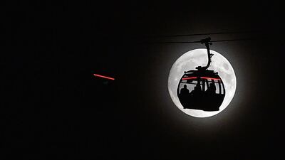 The supermoon rises behind a cable car on The Emirates Air Line in London’s Docklands. Glyn Kirk / AFP