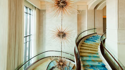 Descend the flowing staircase from the hotel lobby.