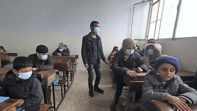 A blind Syrian teacher leads visually impaired pupils during a lesson, respecting social distancing amid the spread of the coronavirus disease, at a school for the blind in the rebel-held northwestern city of Idlib on December 20, 2020. AFP