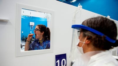 A student from the University of St Andrews takes a swab at a mass testing centre. AFP