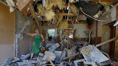 A Ukrainian woman walks through the destroyed home of her son, who was killed the day before by shelling in Donetsk. Reuters